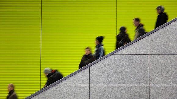 Personnes sur un escalier devant un mur vert