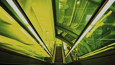 Architecture. Escalator vu de haut. Eclairage intense et vert.