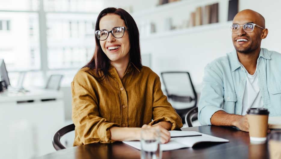 Happy business people sitting in a meeting in an office